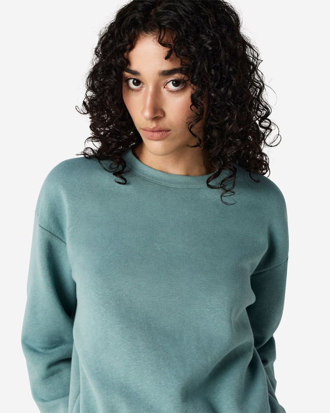 A teal women's crewneck sweatshirt made from fleece, featuring a simple design and a logo.