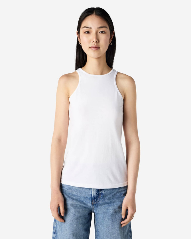 A white women's racerneck tank top with a fitted design, displayed on a model. It features a branding logo.