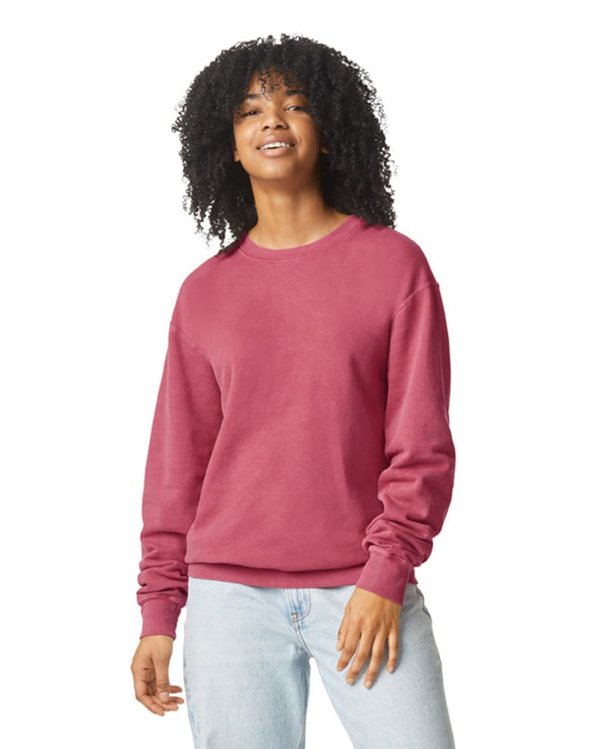A lightweight crewneck sweatshirt in a pink hue, featuring a relaxed fit and long sleeves. It has a logo.
