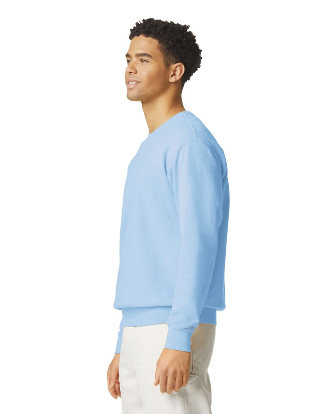 A light blue crewneck sweatshirt is displayed on a model, featuring a simple design and a logo.