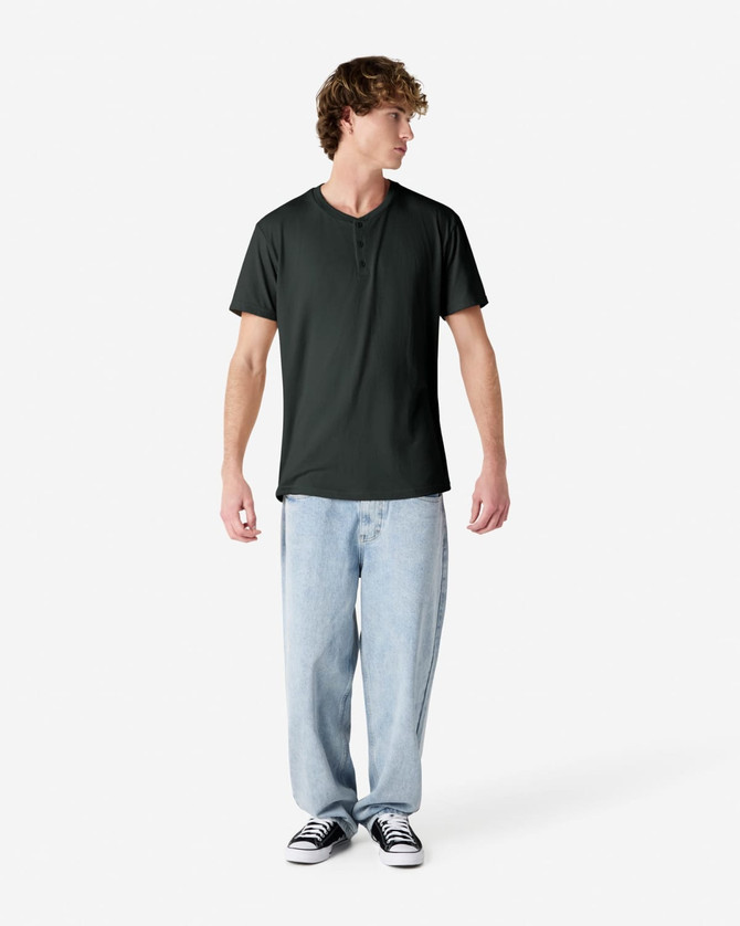 A dark green unisex Henley T-shirt displayed on a model wearing light blue jeans and black sneakers.