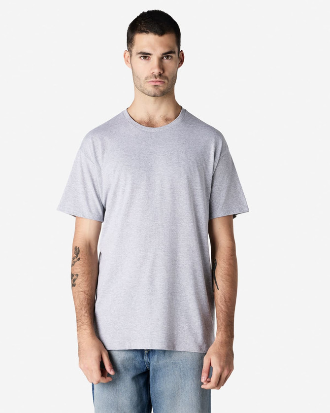 A grey Gildan Light Cotton T-Shirt displayed on a model against a plain background, featuring a logo on the sleeve.