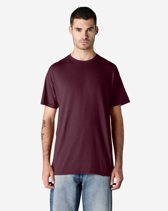 A maroon Gildan Light Cotton T-Shirt displayed on a model wearing denim jeans, featuring a subtle logo.