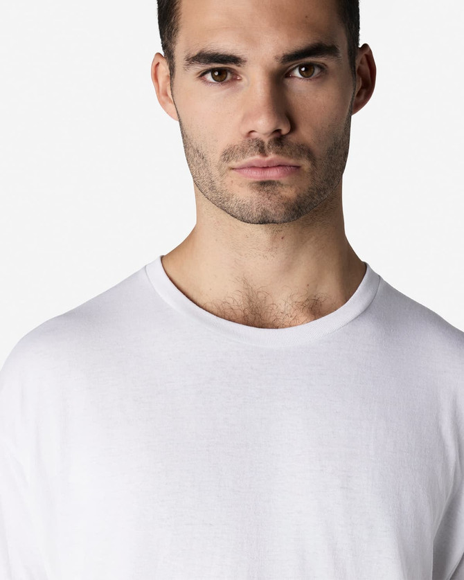A white Gildan Light Cotton T-Shirt worn by a model, featuring a round neckline and long sleeves.