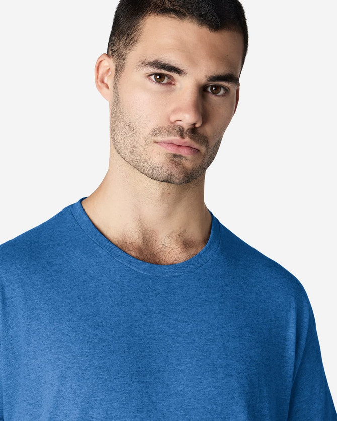 A man wearing a blue Gildan Light Cotton T-Shirt, showcasing its simple design and casual fit.