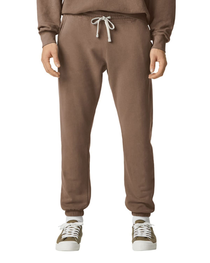 Brown lightweight sweatpants with a drawstring waist, featuring a logo, paired with casual shoes.