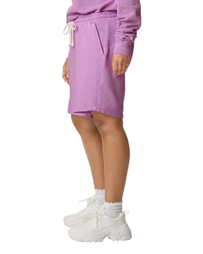 Lightweight sweatshorts in pastel purple, featuring an elastic waistband and side pockets, paired with white footwear.