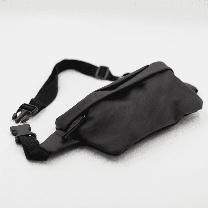 A black Boston Bag with an adjustable strap and a zippered pocket, featuring a simple and sleek design.