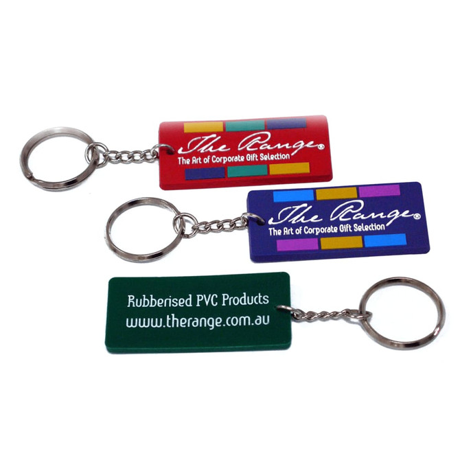A set of three custom PVC keyrings in red, blue, and green, each with a metal keyring attachment and branding.