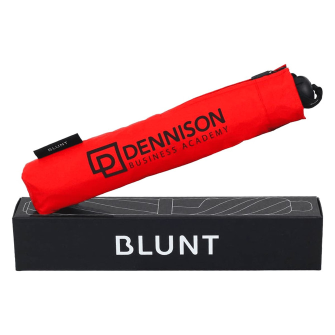 A red BLUNT Metro Umbrella in its packaging, featuring a logo on the cover.