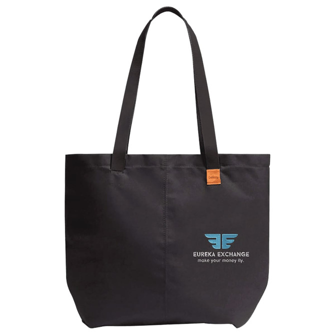 A black tote bag with long handles, featuring a logo on one side and a leather tag.