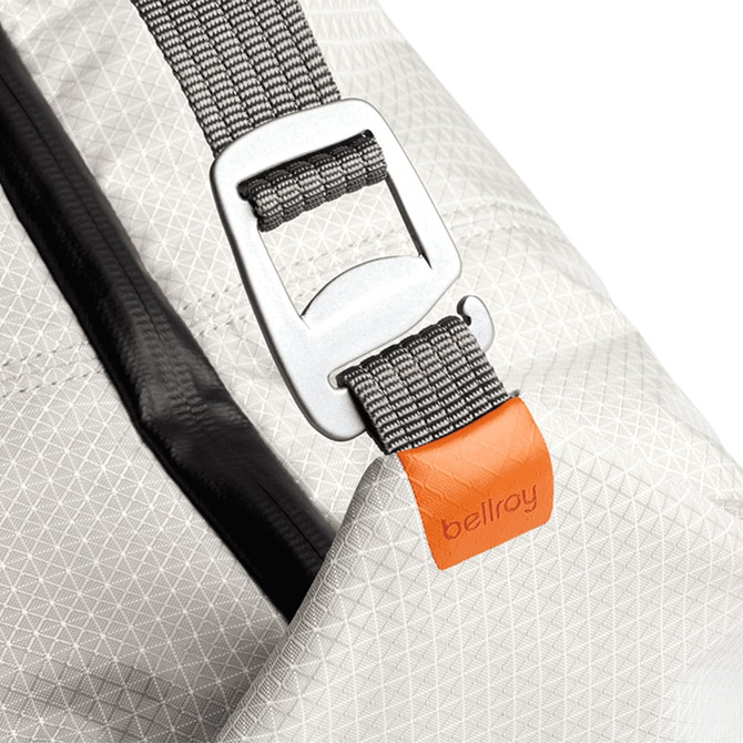 A cooler bag in light grey with a patterned surface, featuring a silver buckle and an orange branding tag.