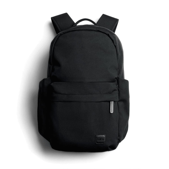A black daypack with adjustable straps and a front pocket, featuring a branding logo.