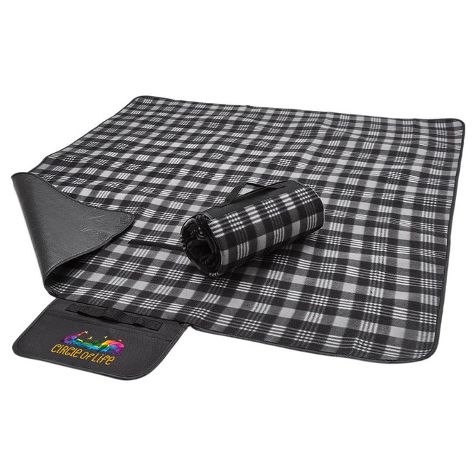 A black and grey checkered picnic rug, rolled up on one side, with a fabric logo patch visible.