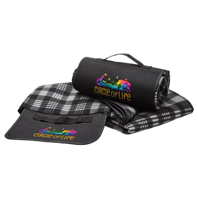 A black and grey picnic rug, rolled up and laid flat, featuring a colourful logo and strap for easy transport.