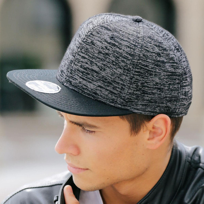 A black and grey cap with a textured design and a flat brim, featuring a logo on the front.