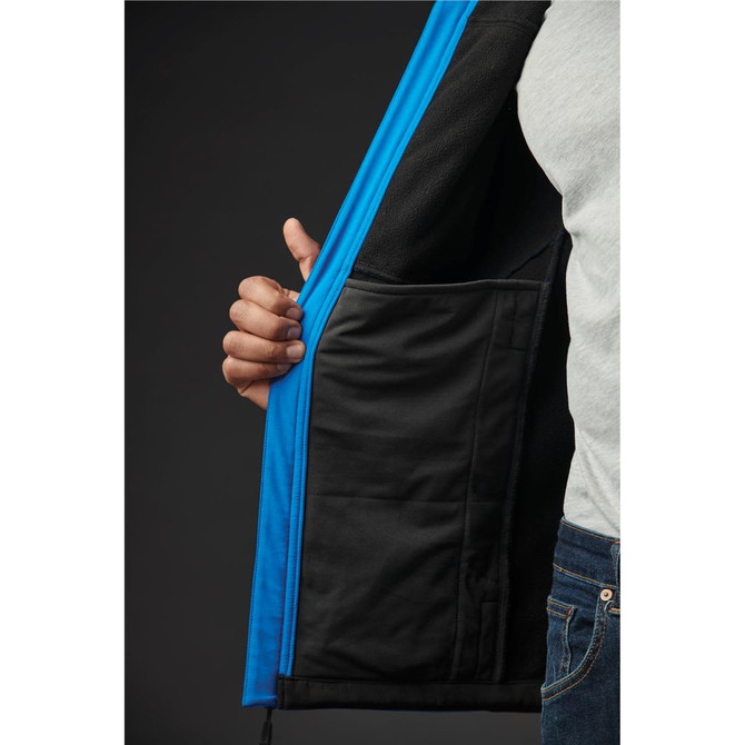 A close-up of a men's softshell jacket featuring blue exterior and a black lining, with a hand holding the open zipper.