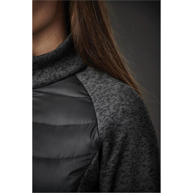 A close-up of a women's hybrid jacket featuring a dark grey knitted fabric and black padded sections.