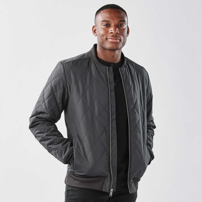 A men's thermal jacket in dark grey with a quilted pattern and a front zip closure. Features a logo on the chest.