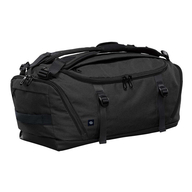 A duffel bag in dark grey with black accents, featuring multiple compartments and carrying handles, and a logo.