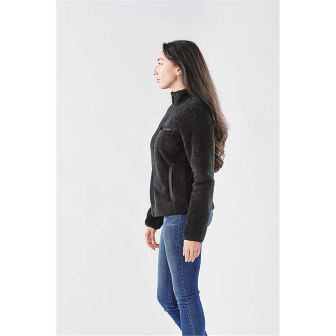 A woman in a black Sherpa fleece jacket, featuring a zip and side pockets, set against a plain background.