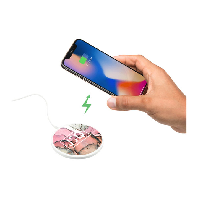 A wireless charging pad with a floral design, connected to a smartphone displaying a charging icon.