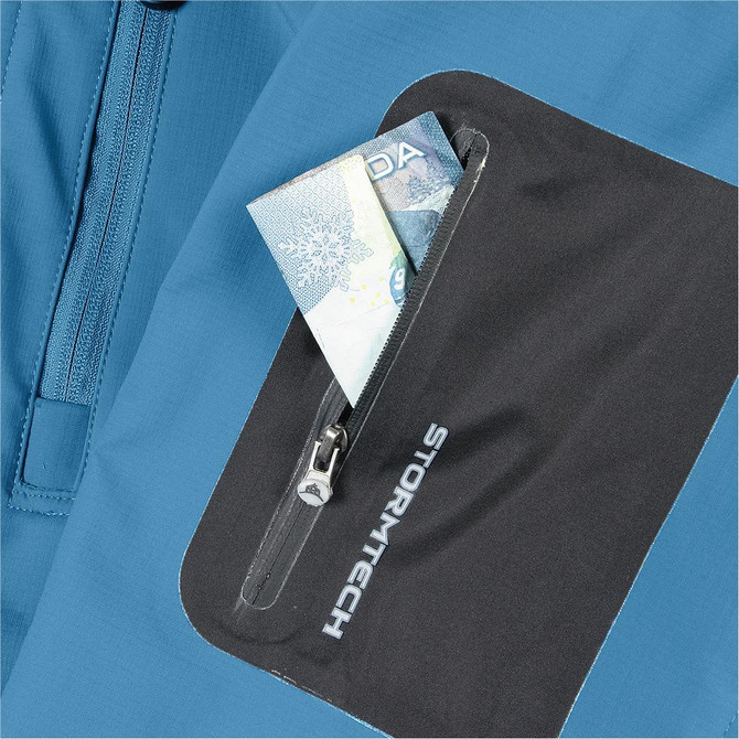 A blue jacket with a black pocket featuring a zip, holding a few notes inside. It has a logo on the pocket.