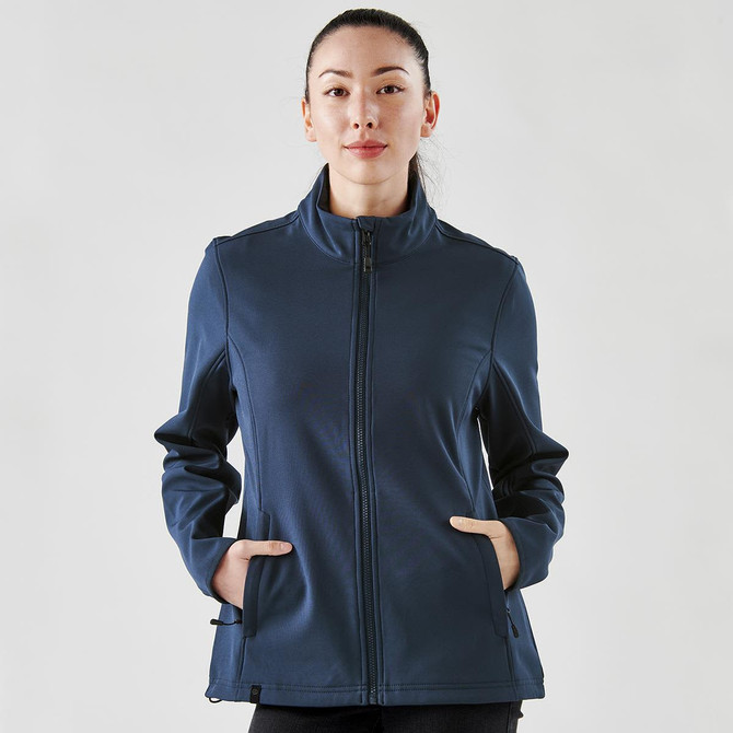 A navy softshell jacket with a front zip and side pockets, worn by a woman. The jacket features a logo.
