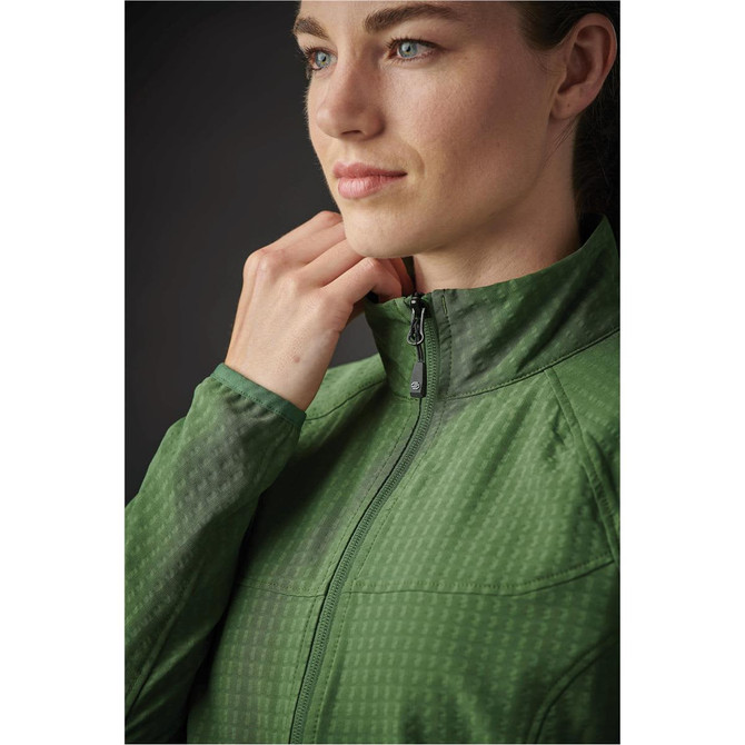 A woman in a green jacket with a zippered collar, featuring a subtle texture and fitted design. The jacket has a logo.