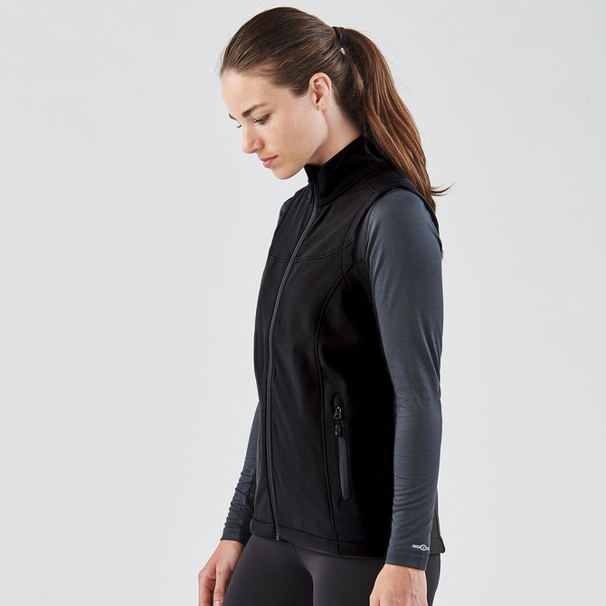 A black softshell vest designed for women, featuring a zip front and side pockets, shown on a model.