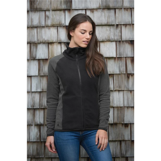 A microfleece jumper in black and grey, featuring a zip front and a high collar, displayed against a wooden background.