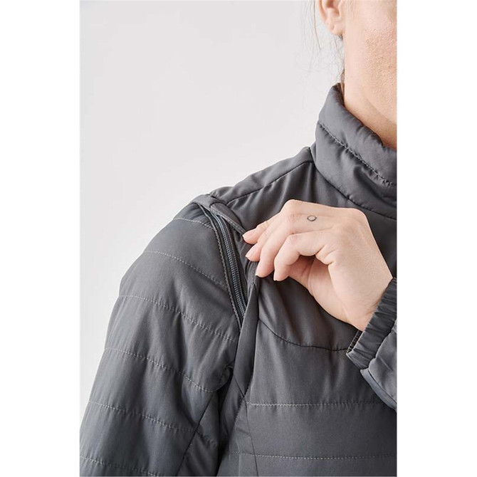 A close-up of a woman's grey jacket featuring a high collar and zippered shoulder detailing.