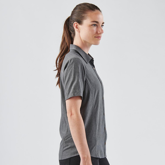 A women's short-sleeve button-up shirt in grey, featuring a sleek design and a logo on the fabric.