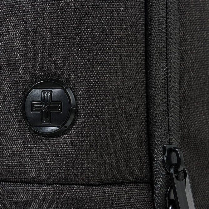 A black backpack featuring a textured surface and a round logo. The zipper detail is also visible.