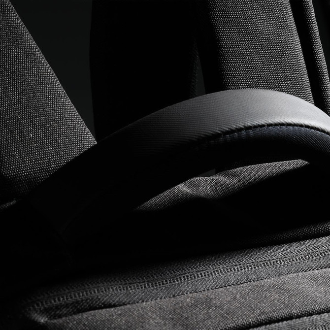 A black backpack featuring padded straps and textured fabric, with a small logo visible.