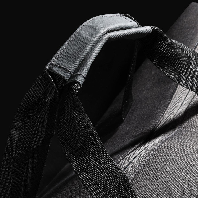 A black duffle bag featuring sturdy straps and a textured design, with branding visible on the surface.