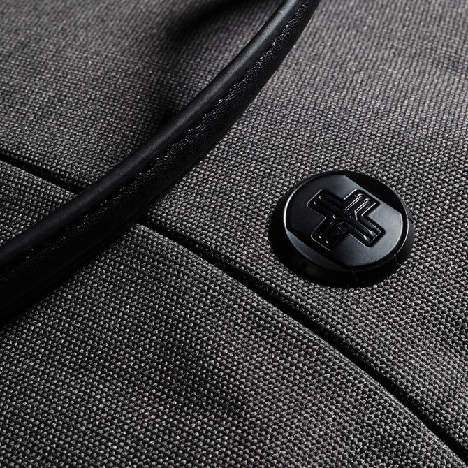 A grey tote bag with a black handle and a circular black logo on the front.