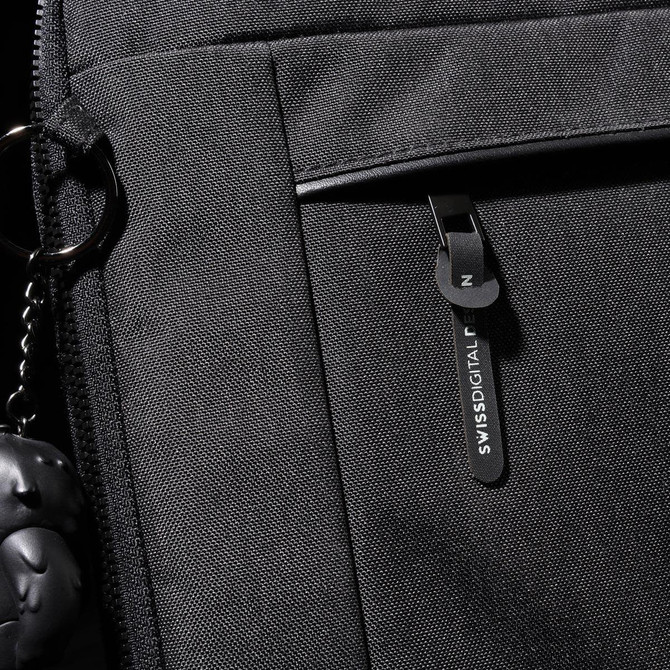 A black laptop sleeve with a zippered pocket and a branded tag. Features a keychain accessory attached.