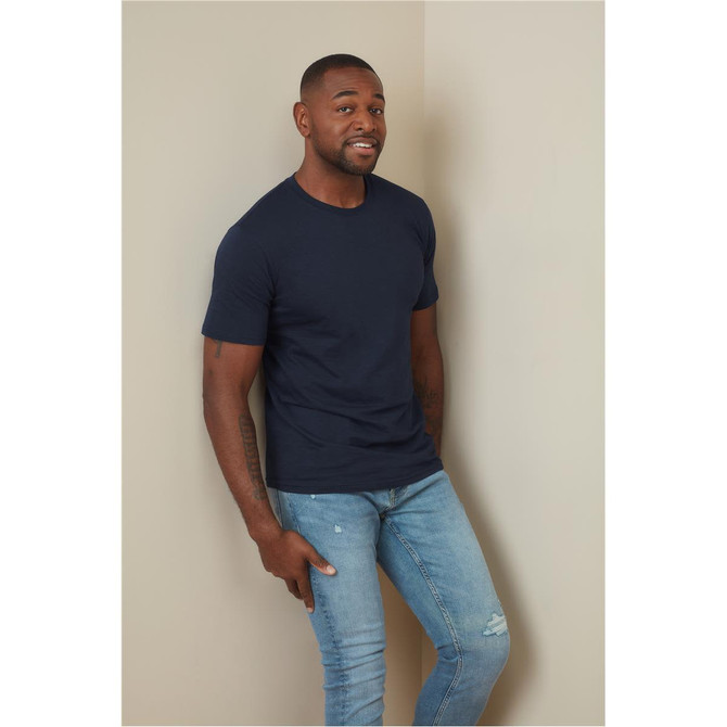 A fitted navy blue T-shirt displayed on a model, paired with light blue jeans, against a neutral background.