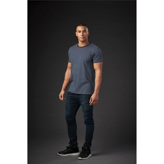 A striped navy and white crew neck t-shirt displayed on a model, paired with dark jeans and shoes.