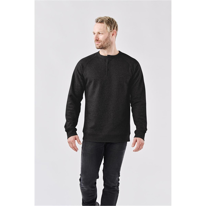 A black men's Monashee Henley shirt with a button detail and long sleeves. The model is standing against a neutral background.