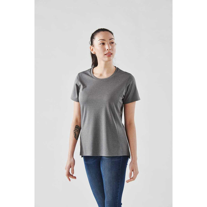 A woman wearing a grey short sleeve performance tee, featuring a rounded neckline and a slightly relaxed fit.