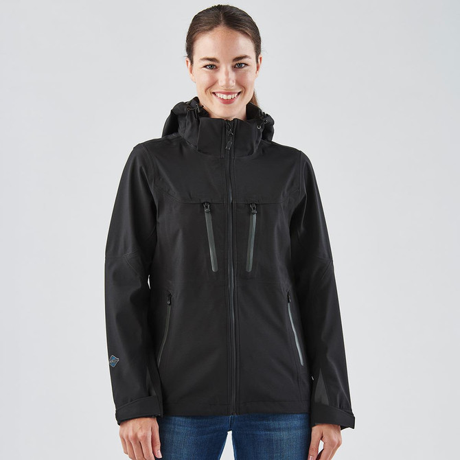 A black women's softshell jacket featuring two zippered pockets and a hood, with a branding logo on the sleeve.