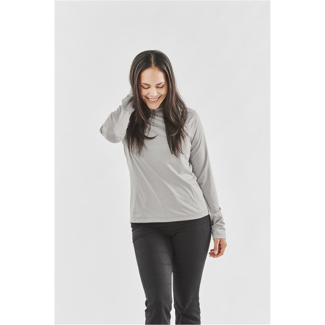 A woman wearing a long-sleeve, light grey women's t-shirt, featuring a round neck and fitted sleeves.
