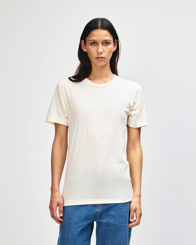 A cream-coloured American Apparel Tri-Blend T-shirt displayed on a model, featuring a simple design and fitted style.