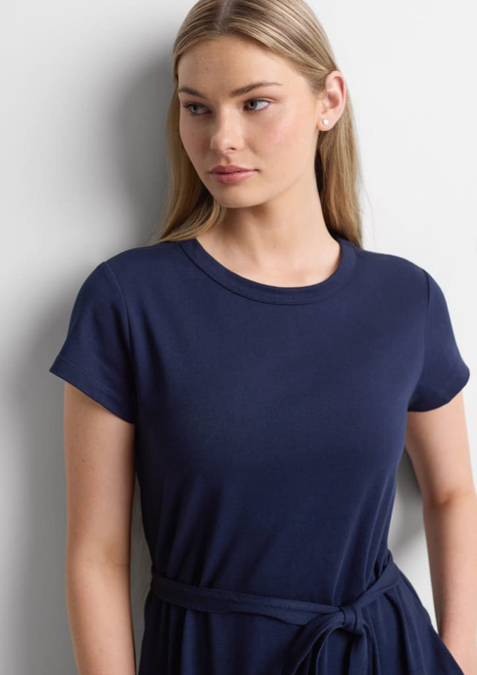 A navy midi dress with short sleeves and a waist tie, modelled by a woman with long hair.