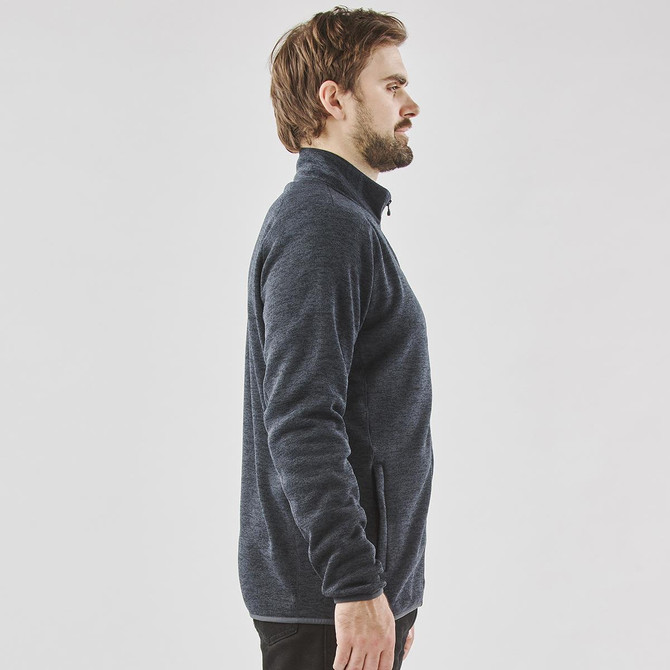 A men's fleece jacket in navy blue with a full zip and side pockets, featuring a subtle logo.