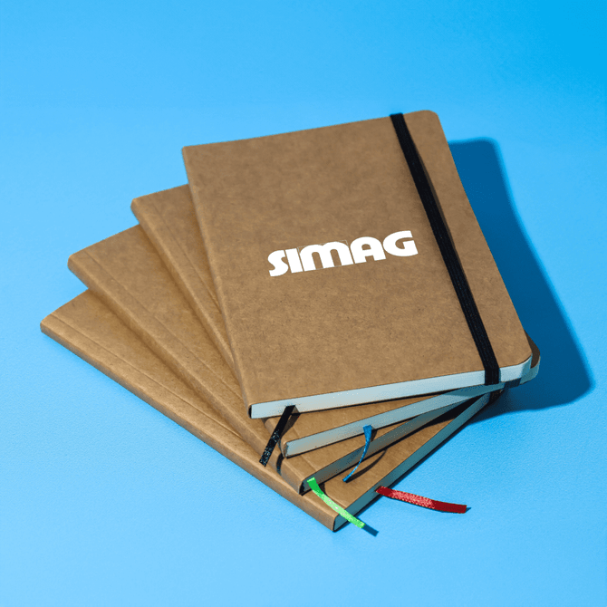 A stack of four brown notebooks with an elastic band closure, featuring a branded logo on the front cover.