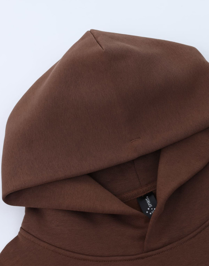 A brown unisex premium fleece oversized hoodie featuring a large hood and a logo.