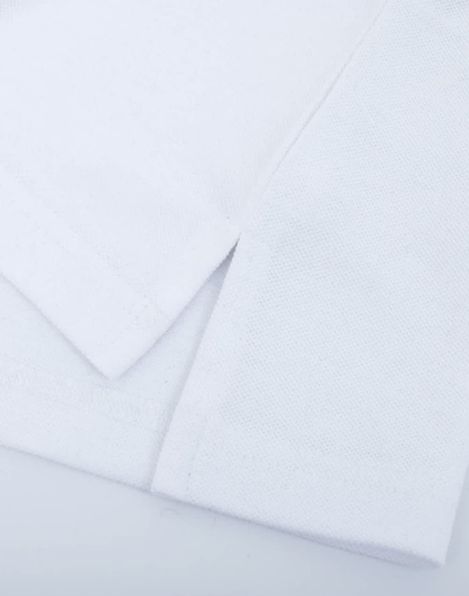A white cotton towel displaying a textured surface and neat edges, featuring a simple design without embellishments.